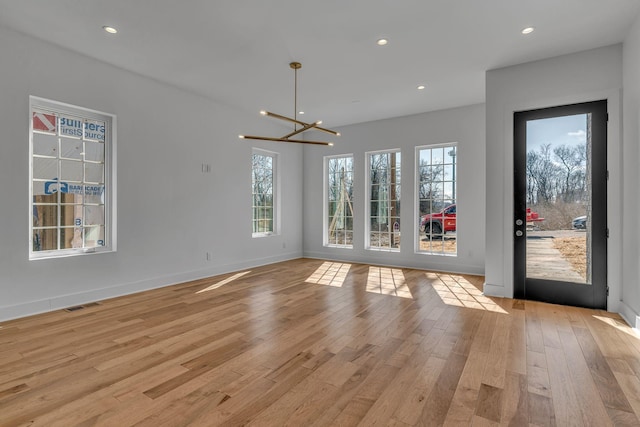 interior space with plenty of natural light, light wood-style flooring, and visible vents