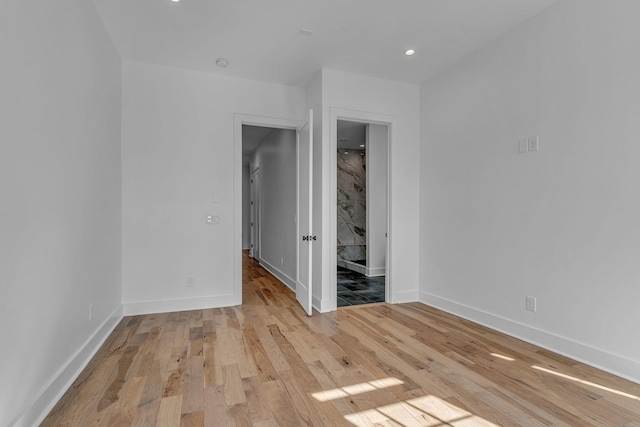 unfurnished room featuring light wood-type flooring, baseboards, and recessed lighting