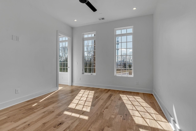 empty room with light wood-type flooring, baseboards, visible vents, and recessed lighting