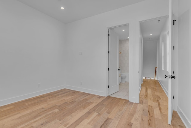 empty room with recessed lighting, light wood-style flooring, and baseboards