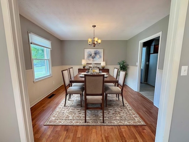 dining area with hardwood / wood-style floors and a chandelier