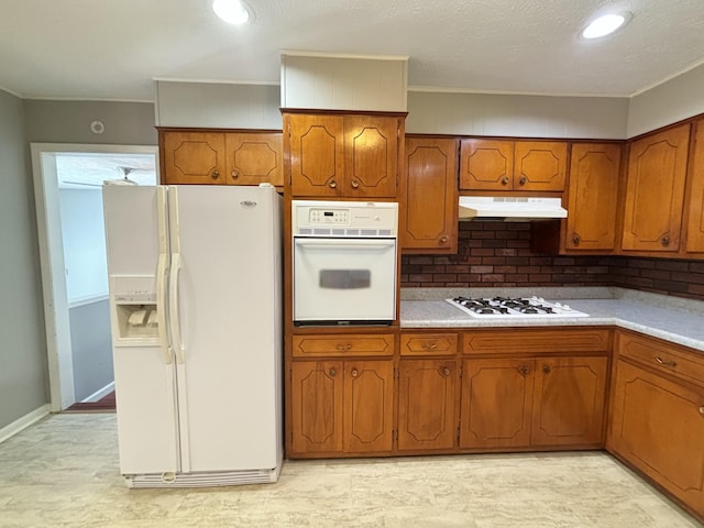 kitchen featuring decorative backsplash and white appliances