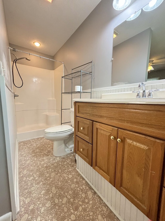 bathroom featuring vanity, toilet, and walk in shower