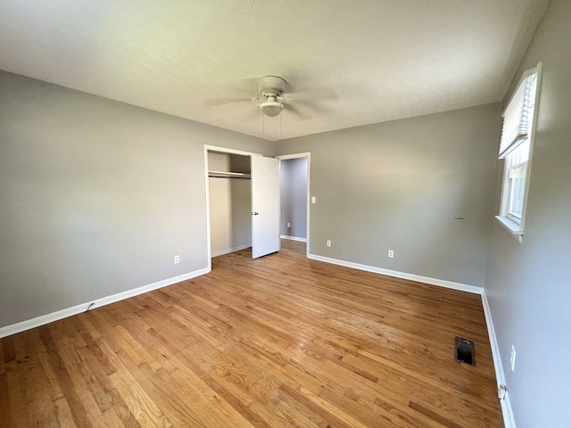 unfurnished bedroom with ceiling fan, a closet, and light hardwood / wood-style floors