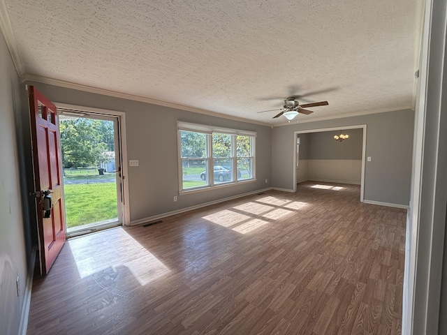 interior space featuring a textured ceiling, ceiling fan with notable chandelier, ornamental molding, and dark wood-type flooring