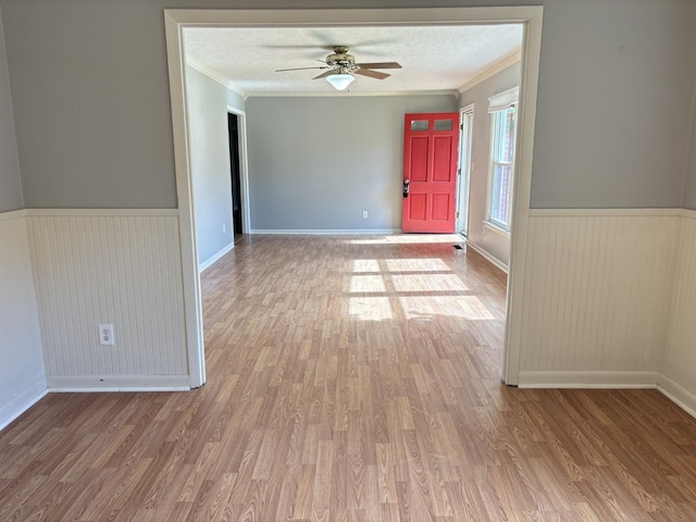 unfurnished room featuring hardwood / wood-style floors, ceiling fan, crown molding, and a textured ceiling