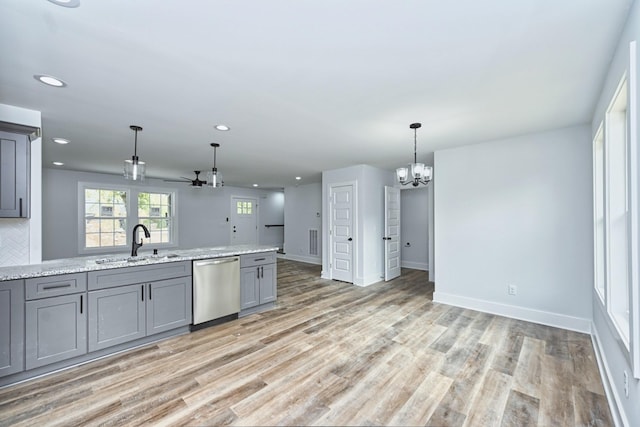 kitchen featuring light stone counters, stainless steel dishwasher, ceiling fan with notable chandelier, sink, and gray cabinets