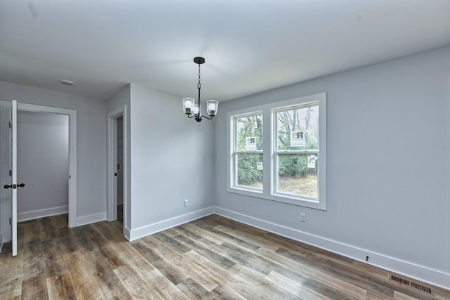 unfurnished room featuring dark hardwood / wood-style flooring and a notable chandelier