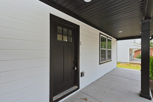 view of exterior entry featuring covered porch