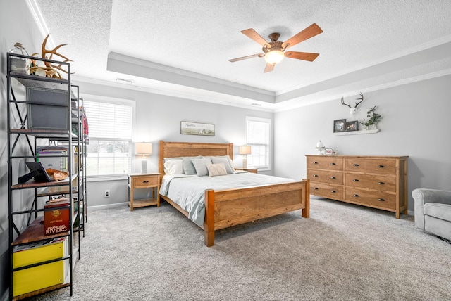 carpeted bedroom featuring a textured ceiling, a raised ceiling, ceiling fan, and ornamental molding