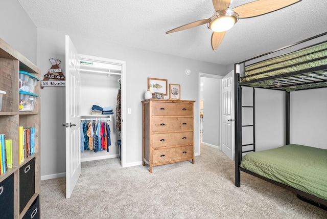 bedroom with light carpet, a textured ceiling, a closet, and ceiling fan