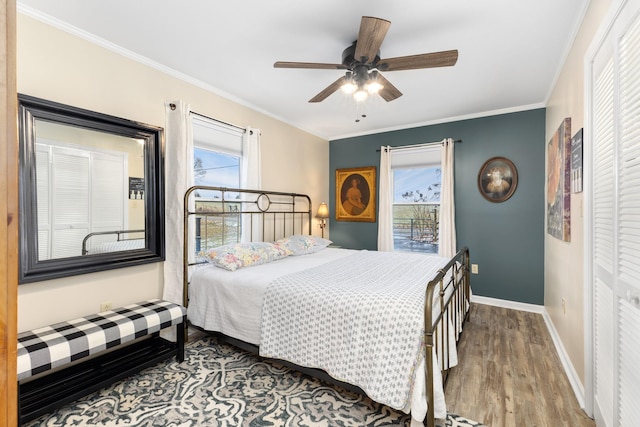 bedroom featuring hardwood / wood-style flooring, ceiling fan, ornamental molding, and multiple windows