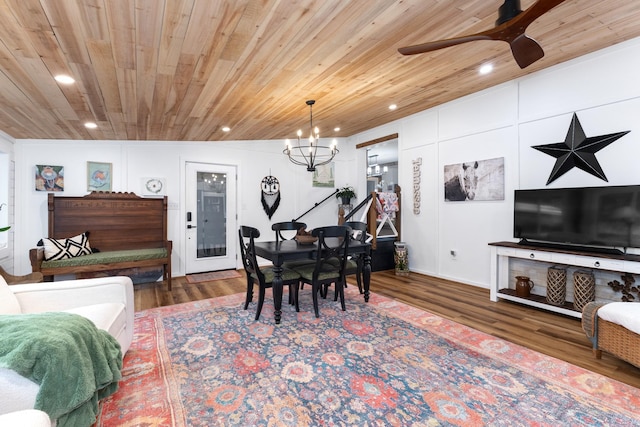 dining room featuring ceiling fan with notable chandelier and dark wood-type flooring