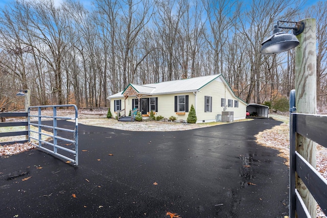 view of side of home with a carport and central AC