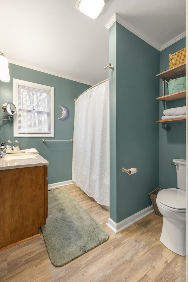 bathroom featuring walk in shower, crown molding, hardwood / wood-style floors, toilet, and vanity