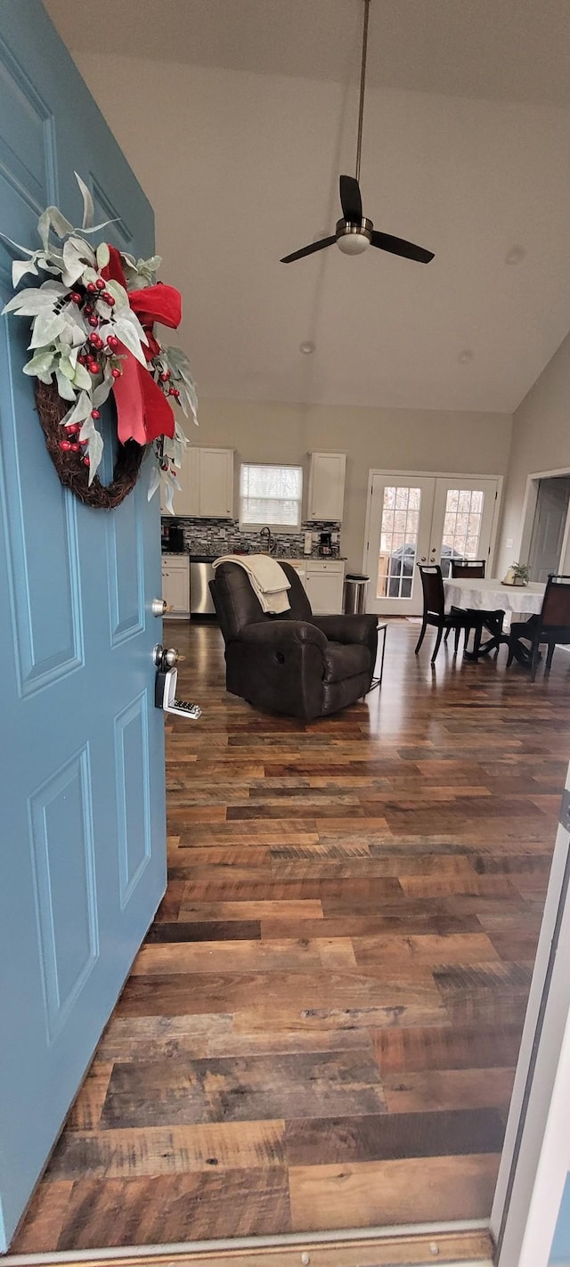 living room with ceiling fan, dark hardwood / wood-style flooring, and lofted ceiling