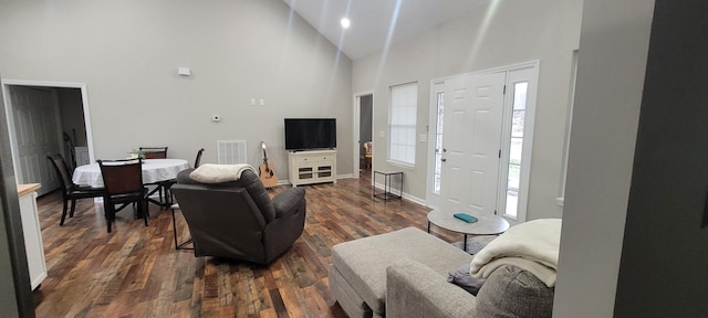 living room featuring high vaulted ceiling and dark hardwood / wood-style floors