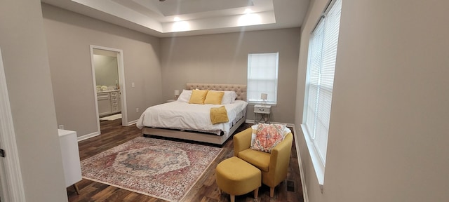 bedroom with dark hardwood / wood-style floors and a tray ceiling