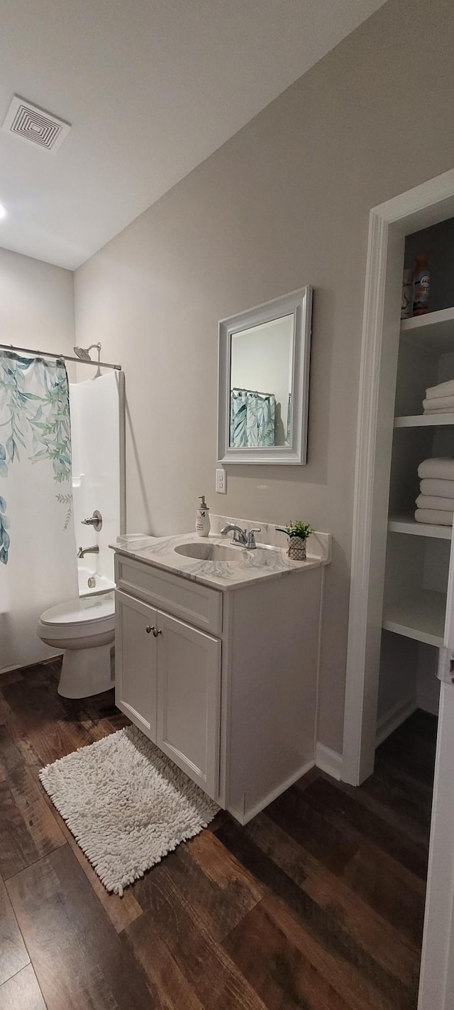 full bathroom featuring shower / tub combo, vanity, hardwood / wood-style flooring, and toilet