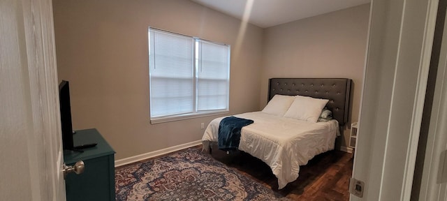 bedroom with dark wood-type flooring