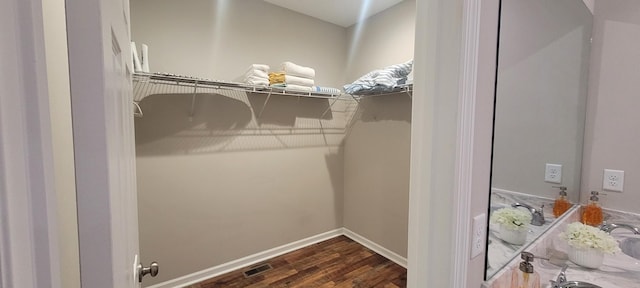 spacious closet featuring dark hardwood / wood-style floors