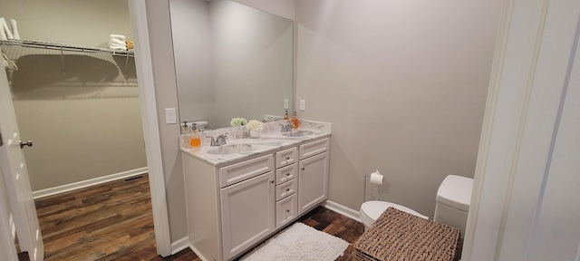 bathroom with toilet, vanity, and hardwood / wood-style flooring