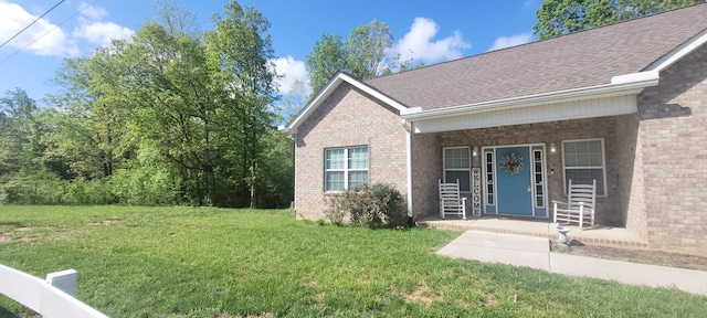 30034 Piper Dr, Bon Aqua, TN 37025 - doorway to property featuring a lawn, brick siding, a shingled roof, and covered porch
