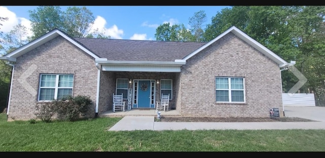 30034 Piper Dr, Bon Aqua, TN 37025 - view of front of house featuring a shingled roof, brick siding, a porch, and a front lawn