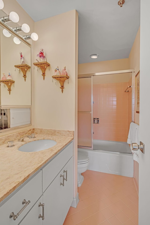 full bathroom with tile patterned flooring, vanity, enclosed tub / shower combo, and toilet