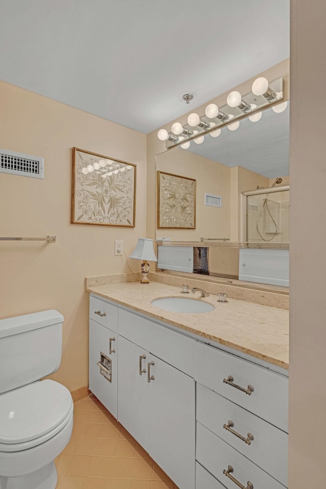 bathroom featuring vanity, toilet, and a shower with door