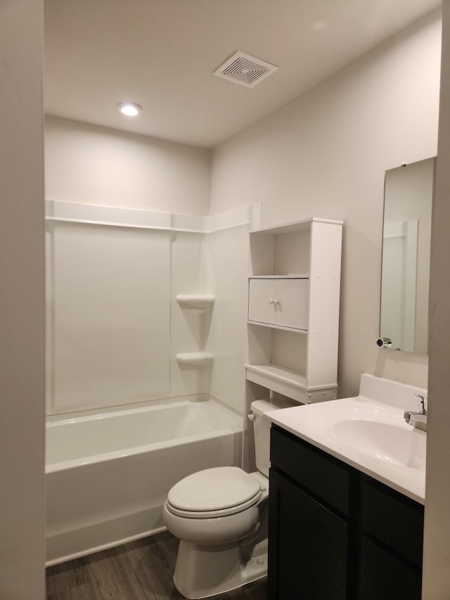 full bathroom with hardwood / wood-style floors, toilet, vanity, and bathing tub / shower combination