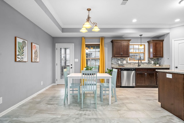 kitchen with pendant lighting, stainless steel dishwasher, tasteful backsplash, dark brown cabinetry, and a chandelier