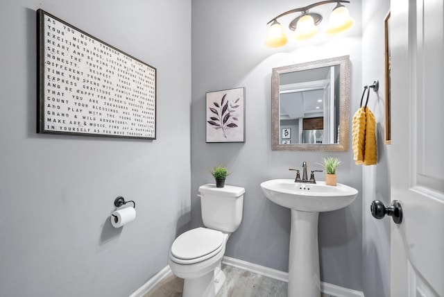 bathroom with hardwood / wood-style floors, toilet, and sink