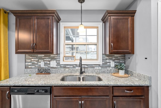 kitchen featuring decorative backsplash, light stone countertops, stainless steel dishwasher, sink, and hanging light fixtures