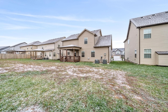 back of property featuring central AC, a yard, and a wooden deck