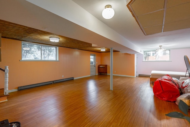 basement featuring hardwood / wood-style flooring and a baseboard heating unit