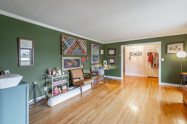 sitting room with light hardwood / wood-style floors and ornamental molding