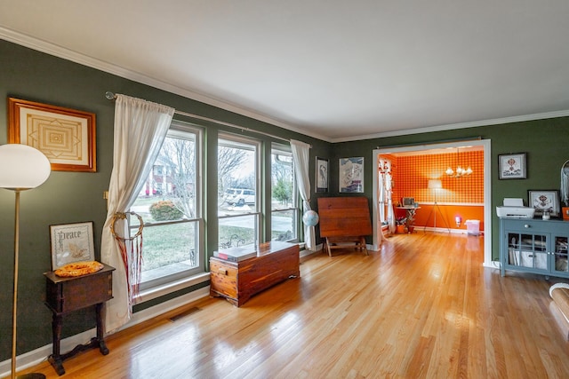 living area featuring light hardwood / wood-style flooring and ornamental molding