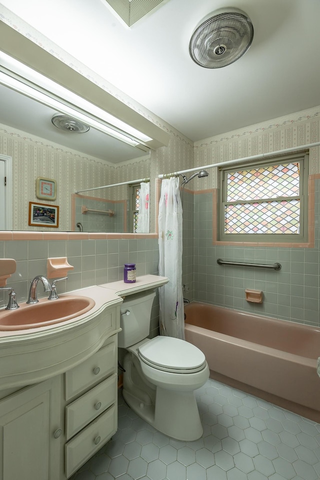 full bathroom with tile patterned flooring, backsplash, shower / bath combination with curtain, toilet, and vanity