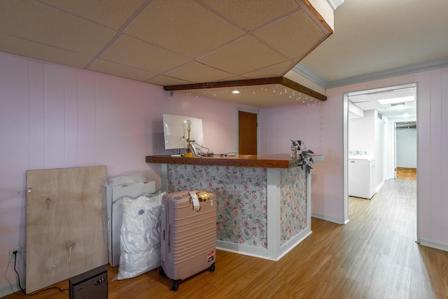 bar with a drop ceiling, wood-type flooring, and washer / clothes dryer