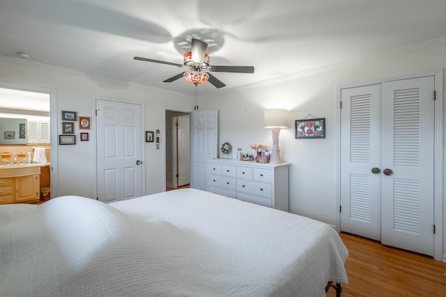 bedroom featuring ceiling fan, crown molding, connected bathroom, and multiple closets