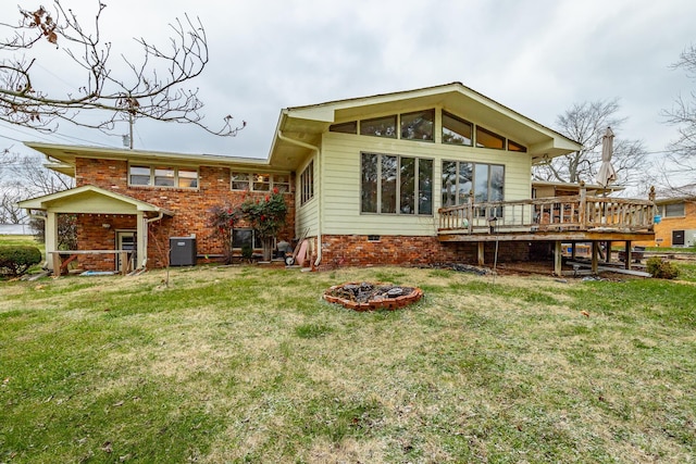 back of house featuring a lawn, a wooden deck, and cooling unit