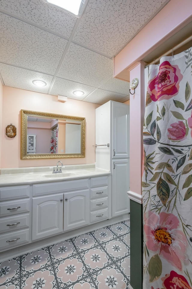 bathroom with a paneled ceiling and vanity