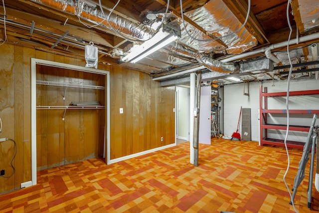 basement featuring wood walls and carpet floors