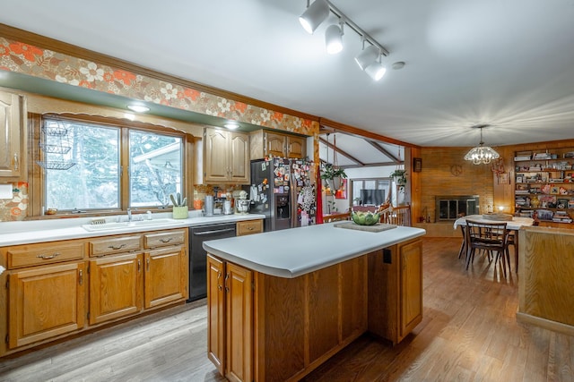 kitchen with sink, decorative light fixtures, dishwasher, stainless steel fridge with ice dispenser, and a center island