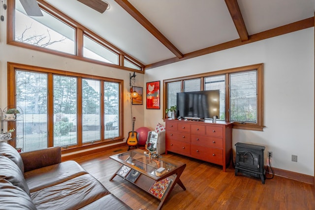 living room with a wood stove, ceiling fan, beamed ceiling, high vaulted ceiling, and hardwood / wood-style floors