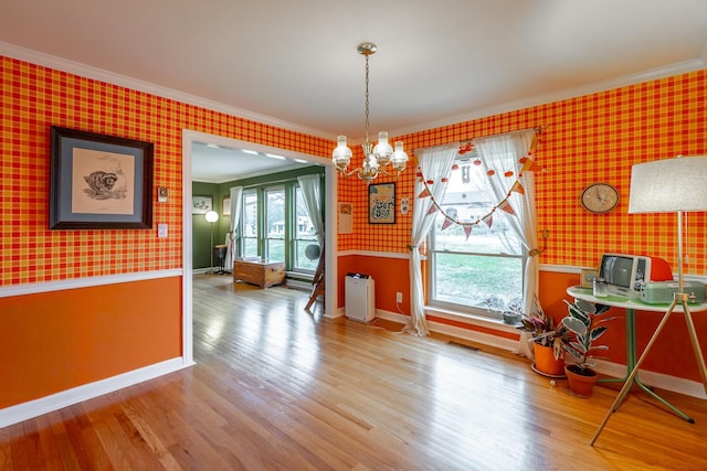 unfurnished dining area featuring hardwood / wood-style flooring, a notable chandelier, and crown molding