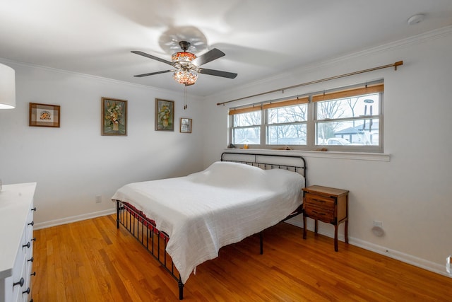 bedroom featuring ceiling fan, light hardwood / wood-style floors, and ornamental molding