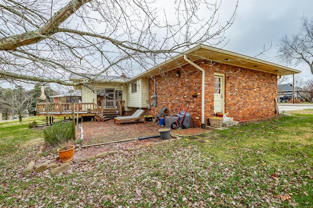 rear view of property featuring a lawn and a wooden deck