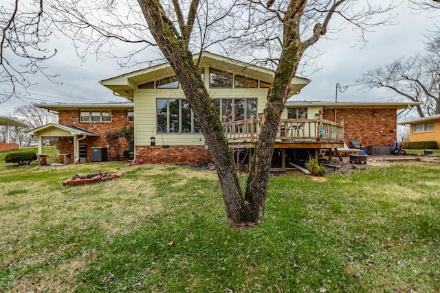 back of property with a wooden deck, a yard, and central AC